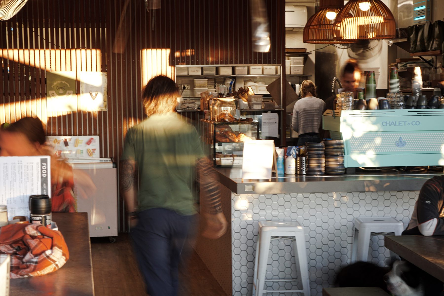 Inside Chalet & Co in golden afternoon light, with the mint coffee machine at the counter