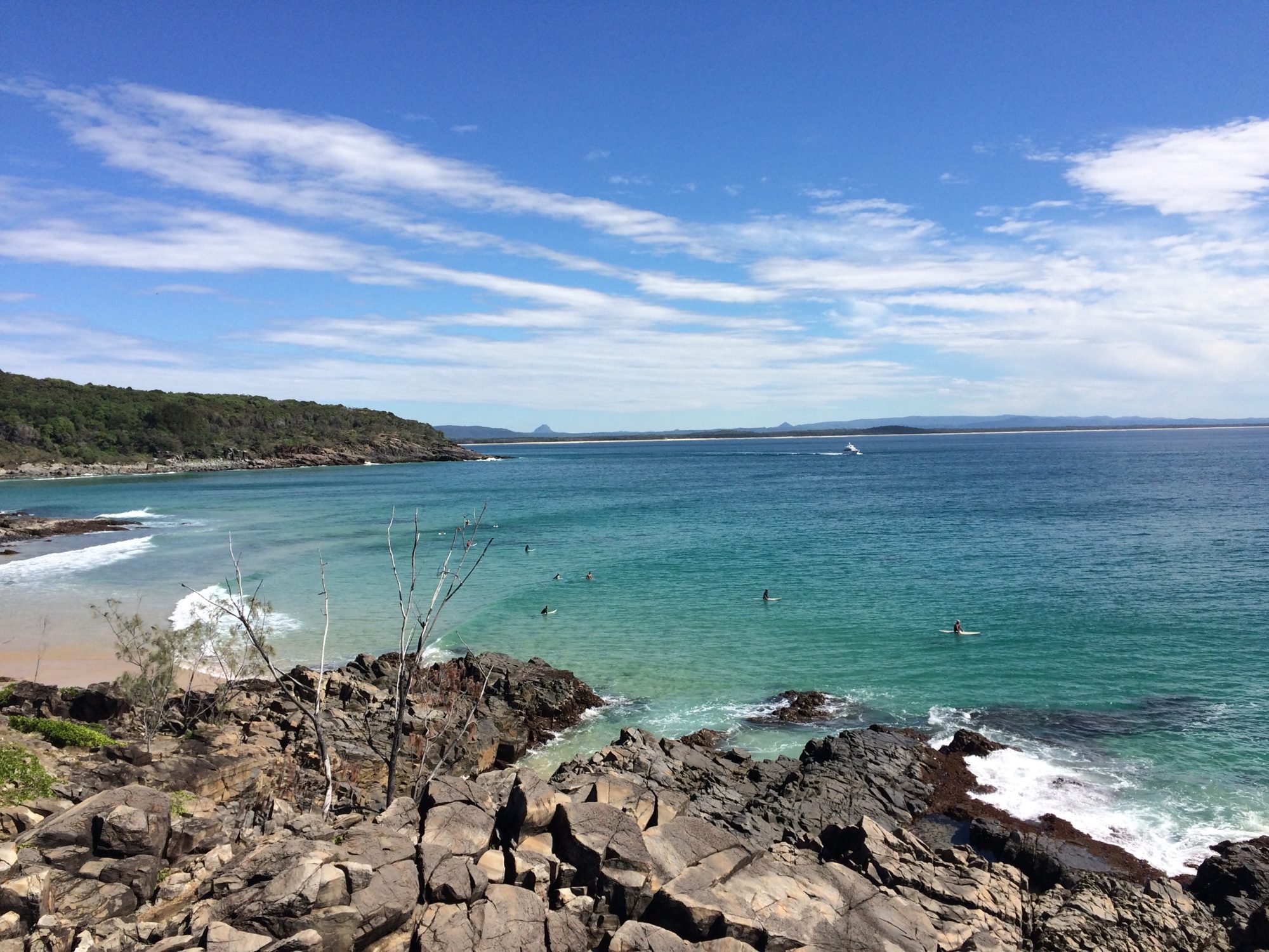 Surfers waiting for waves off the rocks in Noosa National Park