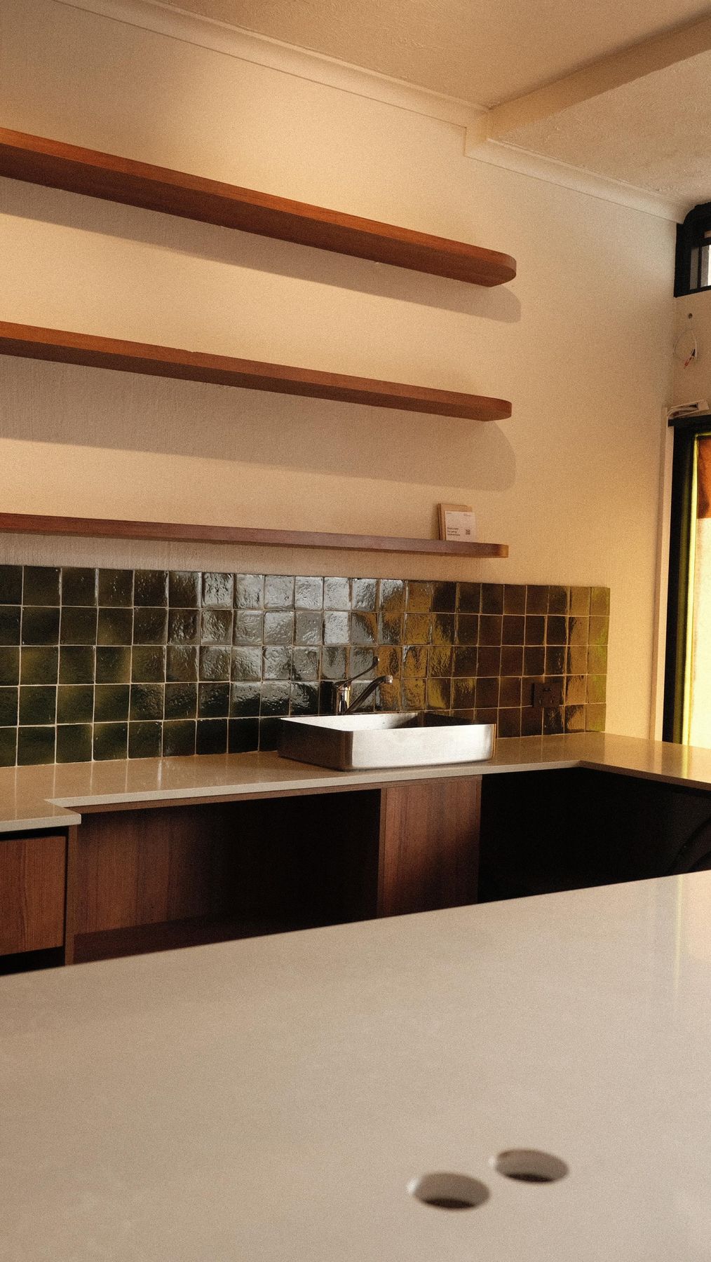 Green tiles and timber shelves