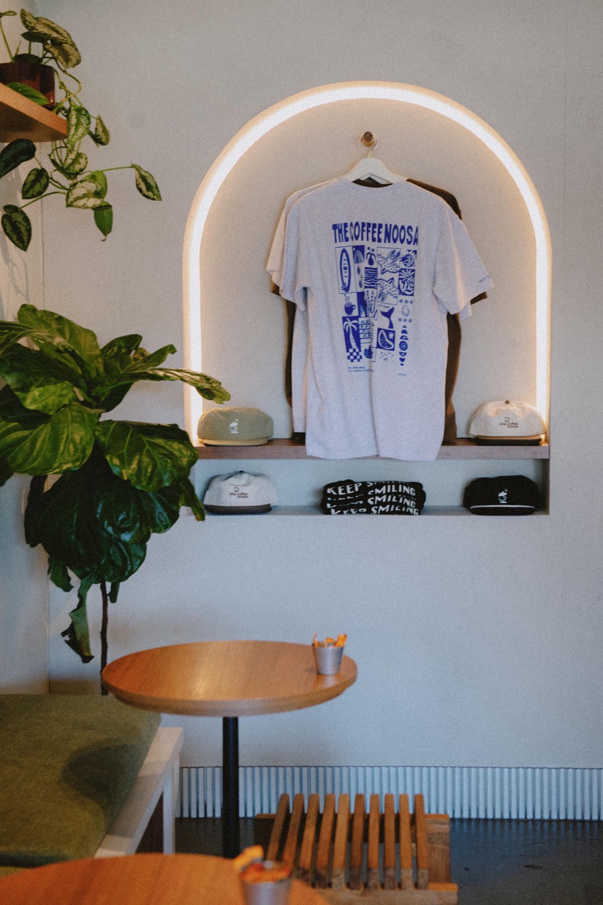 The Coffee Noosa merch displayed in a glowing arch