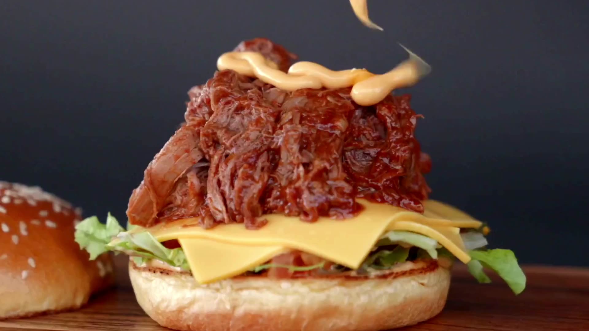 Cheese sauce poured over a smoked brisket burger